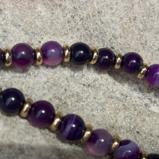 phone chain with purple beads on a textured surface
