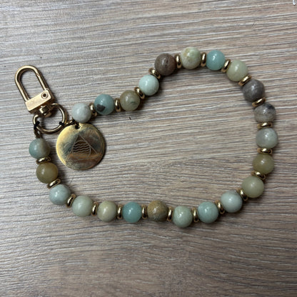 Beaded keychain with a metal clasp on a wooden surface