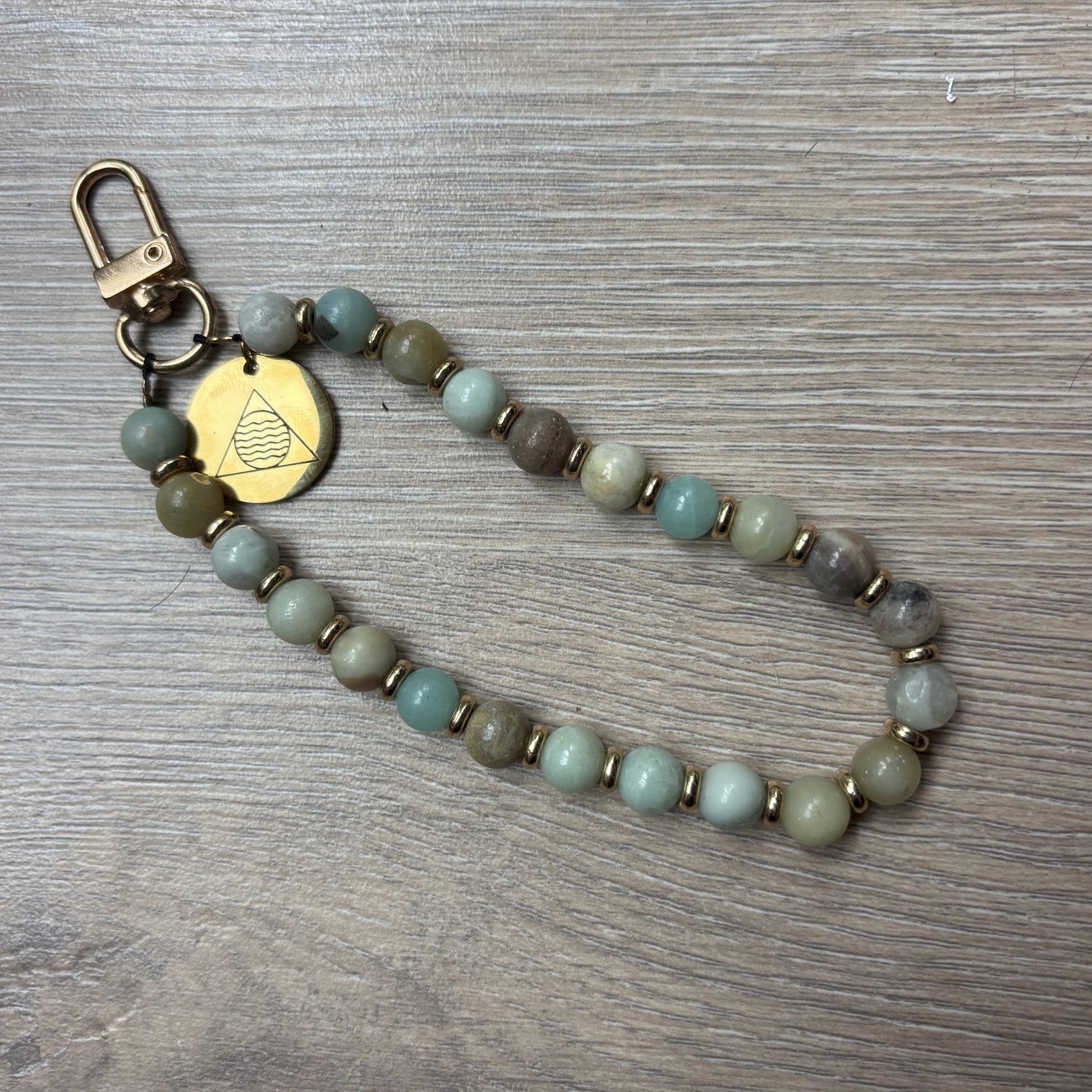 Beaded keychain with a gold clasp on a wooden surface Vishuddha_Throat_Chakra_Chain_1